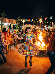 Obraz premium Joyful girl in festa junina dancing near bonfire
