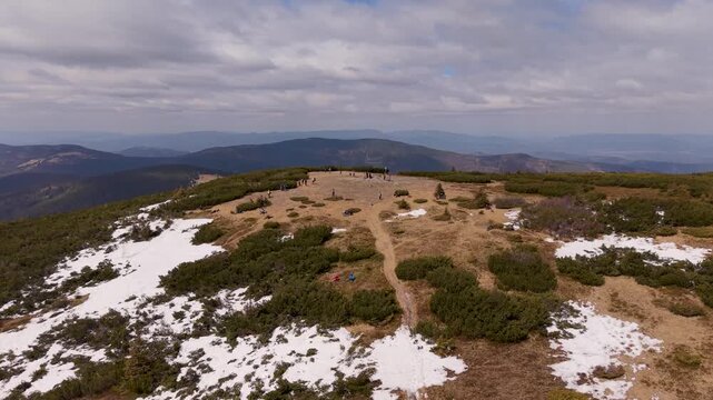 Aerial drone view of Pilsko mountain summit with hikers and snow patches