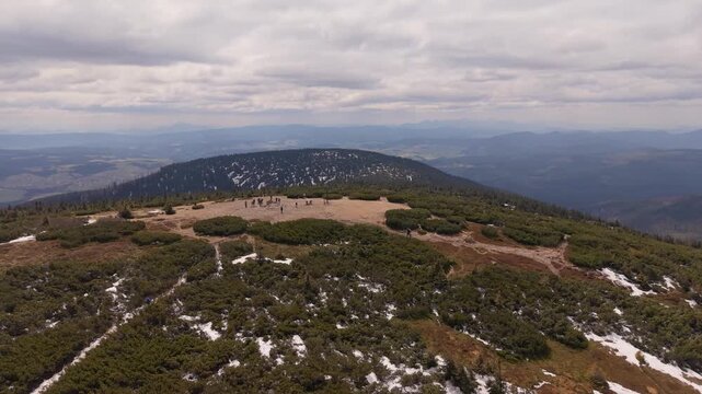 Aerial drone view of Pilsko mountain summit with hikers and snow patches