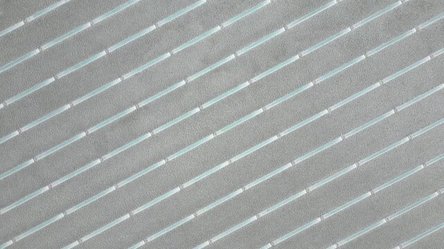 Aerial view of parallel salt extraction channels and geometric patterns on the vast white surface of Salinas Grandes salt flats Tumbaya, Jujuy, Argentina.