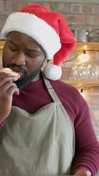 Vertical video: Lifting cookie baker in Santa hat apron testing gingerbread on plate brick kitchen