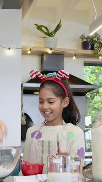 Vertical video: Kid watching adult cracking eggs and stirring batter at home in apron holding spoon