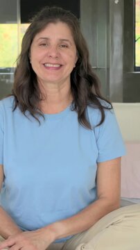 Vertical video: Recording starting, woman in blue tee leaning into lens on bed, rings