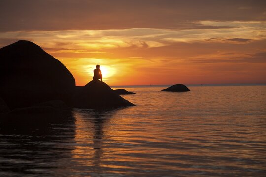 Tourist watching the sunset on Palolem Beach, Goa, India