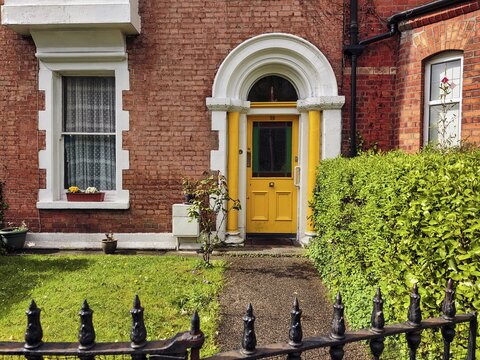 Typical terraced house with small front garden, yellow door, Dublin, Ireland
