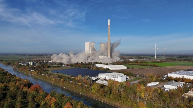 A power plant is being demolished, smoke rises, wind turbines stand next to it in an autumn landscape, blasting of the ash silos, Mehrum coal-fired power plant, Peine district, Lower Saxony, Germany