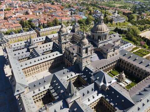Aerial view of a historic monastery with towers and nearby town, surrounded by green landscape, Aerial view, Real Sitio de San Lorenzo de El Escorial, Royal Seat of St Lawrence of El Escorial, palace and monastery complex, San Lorenzo de El Escorial, Madrid, Spain, UNESCO World Heritage Site