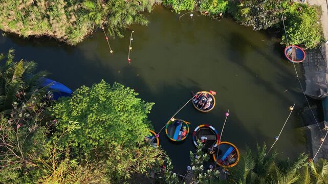 Aerial View Of Riverbank Boat Loading Activities. Cluster Of Coracles And Shaded Pathway Along Riverbank. Vast Scene Of Fishermen And Boats Preparing To Set Out Along River