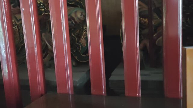 Sign indicating no incense on the table placed on a wooden surface with red wooden slats and decorative elements visible in the background of a traditional setting