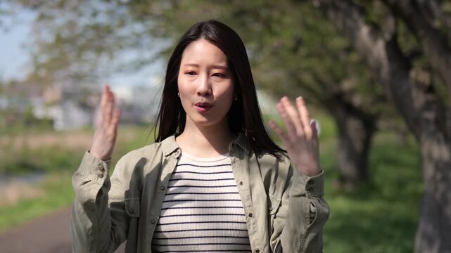 蒸し暑さの中で手で扇ぎながら歩く女性