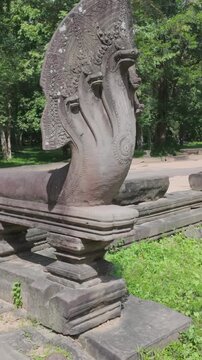 A stone Naga serpent balustrade guards a pathway at Prasat Beng Mealea, Cambodia. The ancient temple complex is a UNESCO World Heritage site.