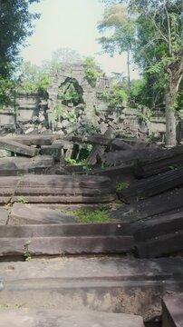 Ancient stone ruins of Beng Mealea temple, Cambodia, overgrown with jungle vegetation, showcasing the passage of time and the power of nature.