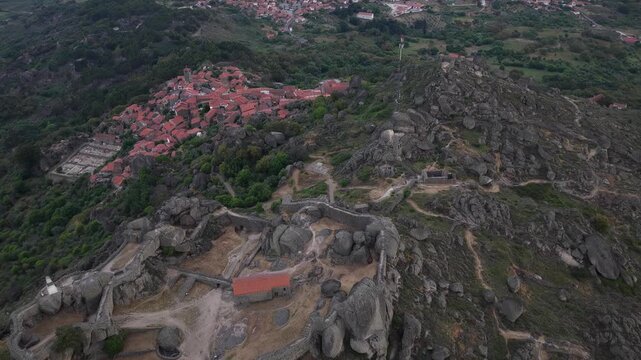 Aerial view of the Castle of Monsanto built into giant boulders on a rocky hilltop with the historic village in the background in Monsanto, Castelo Branco, Portugal.