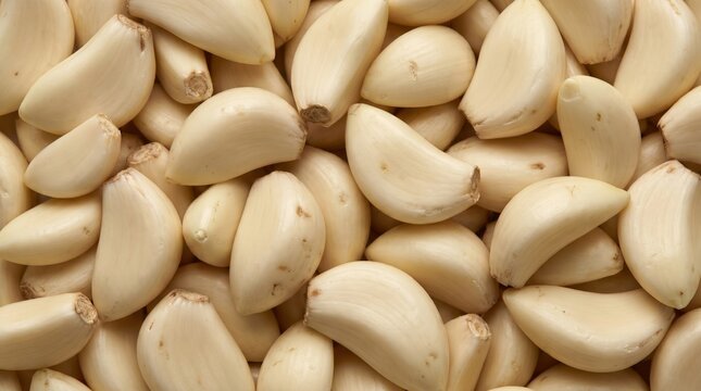 Fresh peeled garlic cloves arranged in a tight pattern creating a natural culinary texture background for professional food photography and healthy cooking concepts