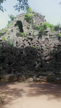 Ancient stone ruins of Beng Mealea temple, Cambodia, overgrown with jungle vegetation, showcasing the destructive power of nature on historical architecture. ,
