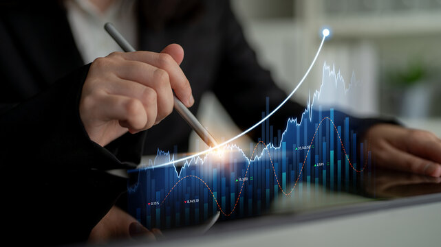 A business professional examines financial trends on a digital tablet, showcasing graphs and charts that represent growth, market investments, and analytical insights. Scalp