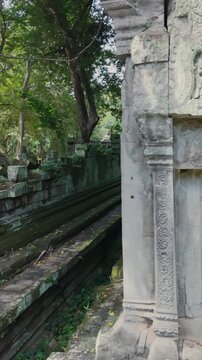 Ancient stone carvings on a temple wall in Prasat Beng Mealea, Siem Reap, Cambodia, showcase intricate details of mythical figures and scenes, hinting at a rich historical past.