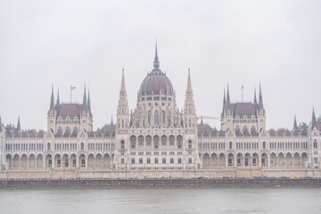 Fototapeta premium Hungarian Parliament Building on the Danube River in Budapest on a Misty Day