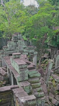 Beng Mealea temple ruins in Cambodia, overgrown with moss and jungle. The ancient stone structures are scattered and reclaimed by nature.