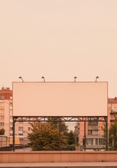 Obraz premium Large blank horizontal billboard panel mounted on a metal structure in a sunny urban setting for outdoor advertising, brand campaigns and media mockups with copy space
