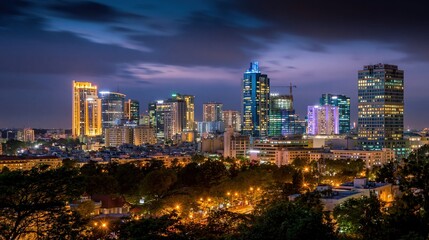 Fototapeta premium Dramatic twilight sky above the urban city skyline at dusk with illuminated office towers and trees for corporate backgrounds, real estate marketing and travel websites