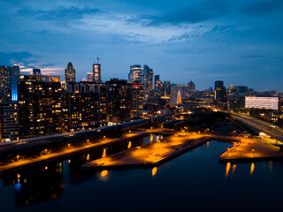 Fototapeta premium Montreal skyline illuminated at dusk and reflected in the water, Quebec, Canada.