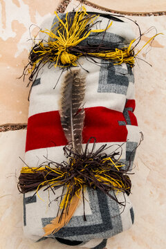 Native American regalia bundle with feathers and woven textile