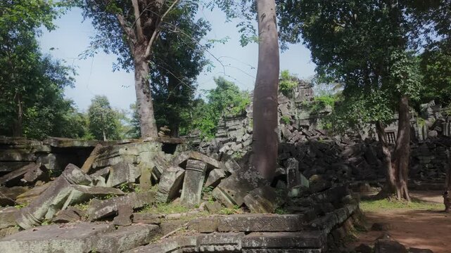 Ancient stone ruins of Prasat Beng Mealea overgrown with vegetation in Cambodia. The crumbling structures hint at a lost civilization and the passage of time.