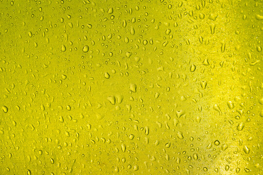 Green yellow tent fabric with raindrops showing water droplets on waterproof material creating romantic tourism background texture