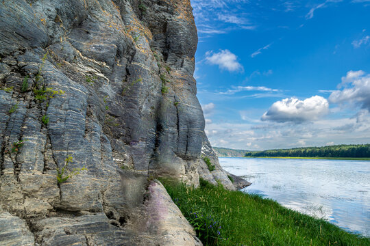 Massive Devonian limestone cliff with horizontal stratification and lichen growth along Tom River right bank in Kemerovo Oblast