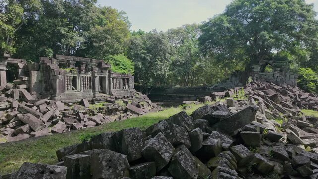 Ancient stone ruins of Beng Mealea temple, Cambodia, overgrown with trees and scattered with large rocks, showcasing the jungle's reclamation of the historic site.