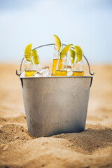 Icy beer bucket with lime wedges at a sandy beach in Colombia © Diogo