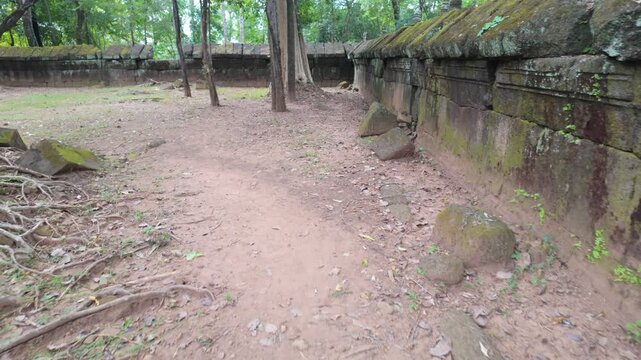 Ancient stone ruins overgrown with moss and trees in a jungle setting. Koh Ker, Siem Reap, Cambodia.