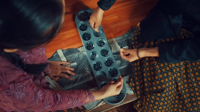 Top Down View of Women Playing Congklak