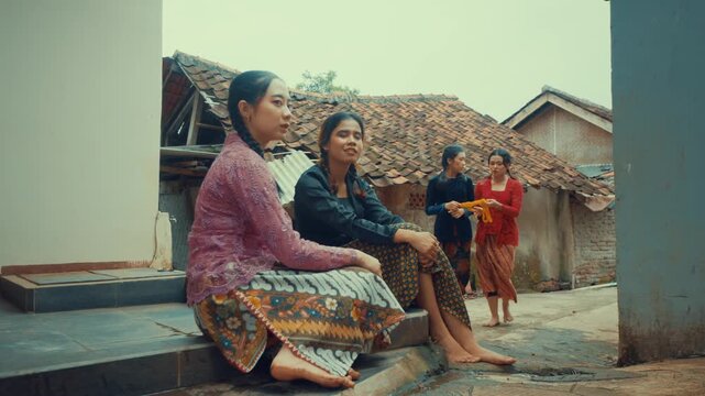 Two Women Sitting Watching Friends with Rope
