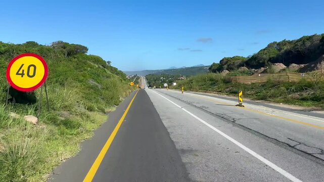 Traffic navigates through a construction zone on a highway near Riversdale, South Africa. Useful for infrastructure projects or travel narratives.