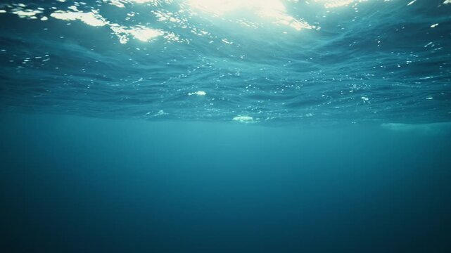 Soft Arctic underwater light filtering beneath calm Norway ocean surface ripples