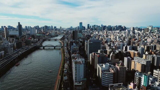 Drone sliding over Sumida River in Asakusa, Tokyo Japan, dense urban megacity