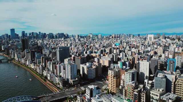 Drone flying forward over Asakusa Tokyo Japan with river bridges and skyline