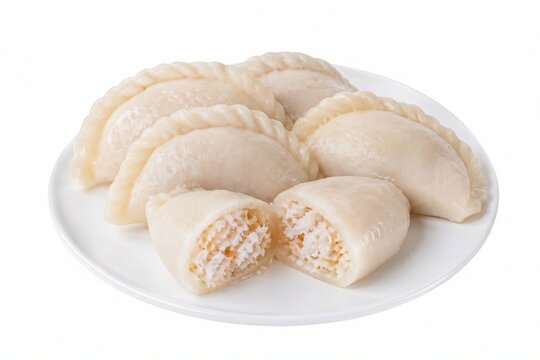 Traditional Bengali coconut stuffed pitha rice cake on white plate isolated on white background