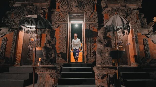 Balinese Man Walking Through Temple Gate at Night