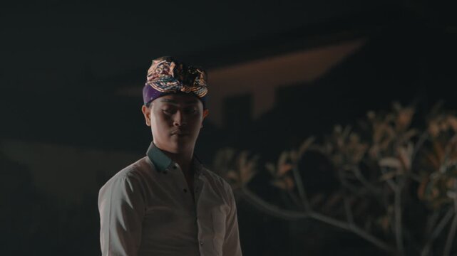 Balinese Man Turning Away in Dark Night Setting