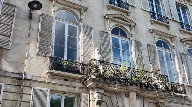 Classic Parisian Building Facade with Arched Windows and Wrought Iron Balconies