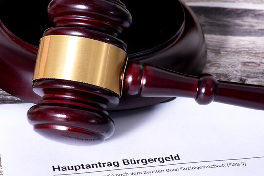 Antrag auf B&uuml;rgergeld und Richterhammer als Symbol f&uuml;r eine Klage gegen das Jobcenter