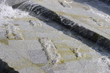 Water cascades over rough, mossy stone surfaces © gelog67