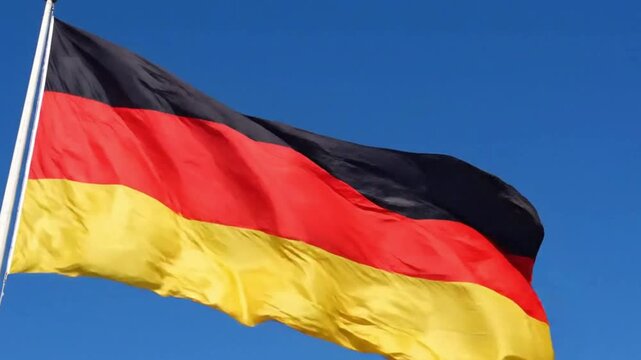 The national flag of germany waving against a clear blue sky