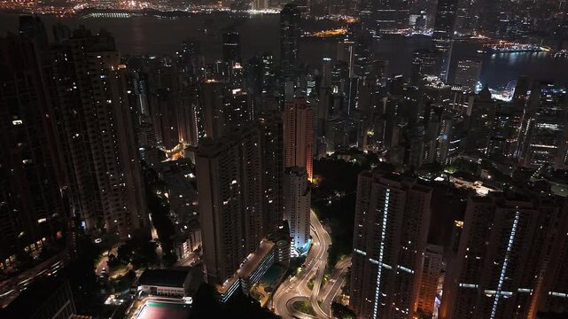 Wide drone shot panning across Hong Kong downtown and bay area at night.