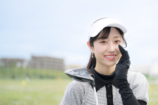 ゴルフ練習場で上達や成功を喜ぶ、応援や口コミポーズの女性のスポーツライフスタイルイメージ　カメラ目線の笑顔