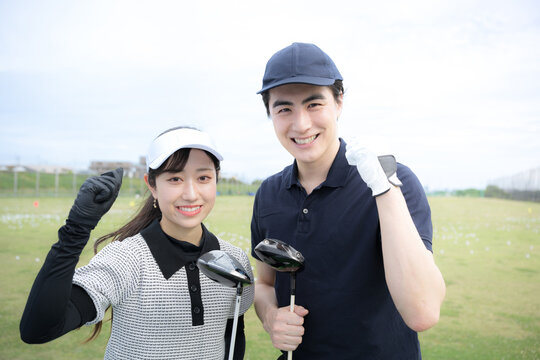 ゴルフのレッスンや習い事のイメージ　女性と先生のガッツポーズカメラ目線