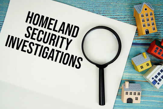 Notepad with "HIS Homeland Security Investigations" with magnifying glass and house model on wooden background